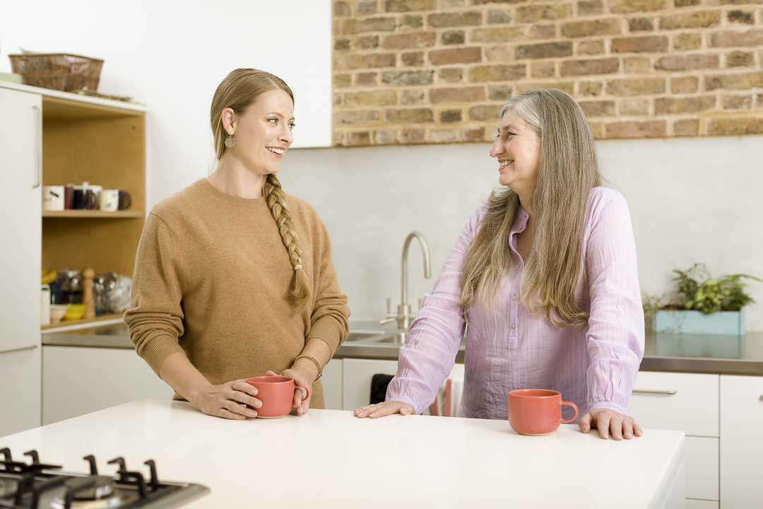 Women kitchen discussion smiling
